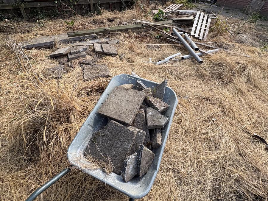 Kruiwagen met oude tegels uit de tuin