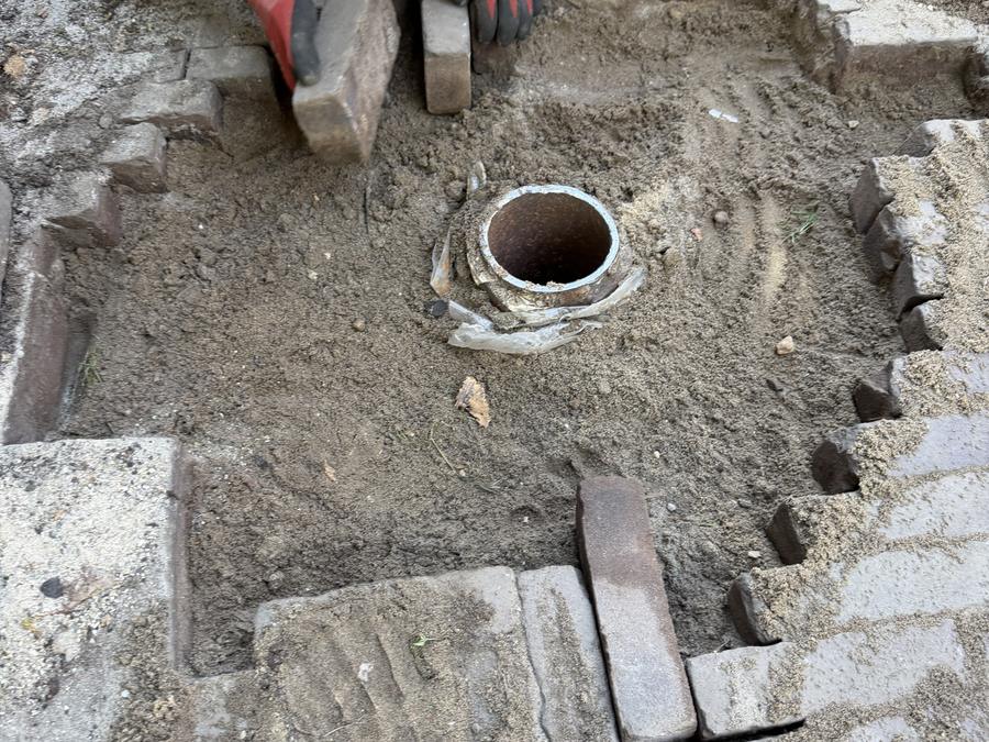 Bestrating eruit halen rond een afvoerput