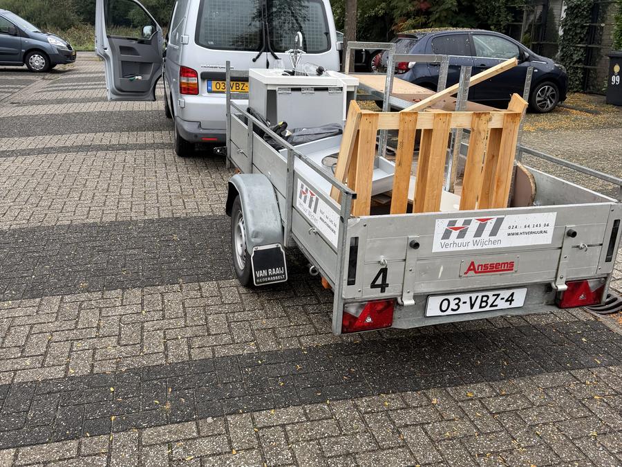 Aanhanger met hout achter de HKX-bus